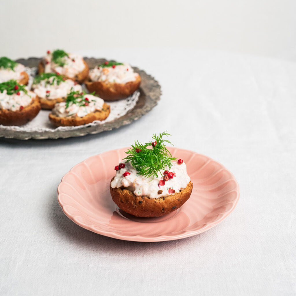 K. Leivon saaristolaiskorppu täytettynä kylmäsavulohitäytteellä, koristeltu tillillä ja rosepippurilla, valmiina tarjoiluun.